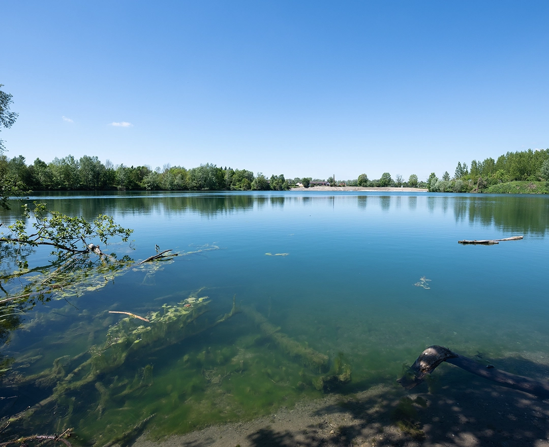 Ein strahlender blauer Himmel spiegelt sich im Gewässer, das Teil der Fischwanderhilfe bei Abwinden-Asten ist.